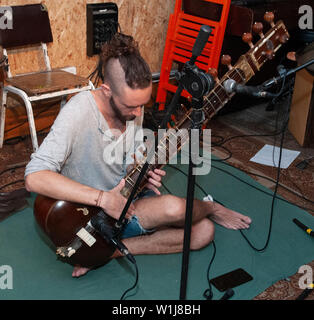 Junge kaukasier Musiker spielt eine Sitar Stockfoto
