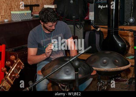 Junger Mann spielt das Hang, ein Musikinstrument in der idiophone Klasse Stockfoto