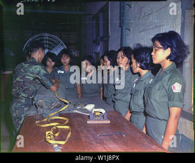 Sergeant Sans beauftragt WAC Klasse auf pack Schließen der T-10 Fallschirm am 90. Antenne Ausrüstung Depot, Saigon. Stockfoto