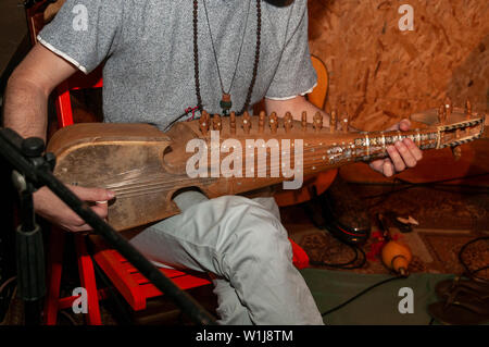 Junge kaukasier Musiker spielt eine afghanische Rebab Streichinstrument Stockfoto