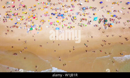 Überfüllten, öffentlichen Strand mit bunten Sonnenschirmen, Luftbild. Stockfoto