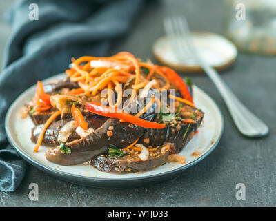 Salat eingelegte Auberginen, Möhren, Zwiebeln, Paprika in der Platte auf dem schwarzen Stein. Fermentierter Lebensmittel auf dunklen Tisch. Konservierte Gemüse. Kopieren Sie Platz für Text Stockfoto