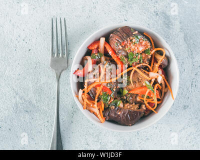 Salat eingelegte Auberginen, Möhren, Zwiebeln, Paprika in Schüssel auf grauzement Hintergrund. Fermentierter Lebensmittel. Konservierte Gemüse. Kopieren Sie Platz für Text. Top View oder flach. Stockfoto