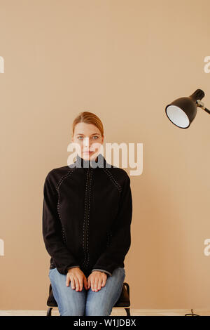 Kurzhaarige Frau im Sessel vor Studio Light Stockfoto