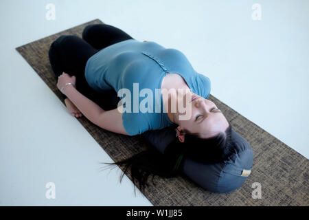 Cauacasian Frau in Liegeposition held Supta Virasana ruhend Stellen oder mit Polstern, Stretching nach dem Üben. Studio shot Stockfoto