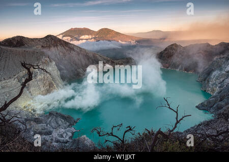 Aktive Vulkan Krater mit türkisfarbenen See und Schwefel Rauch in den Morgen in der Kawah Ijen, Indonesien Stockfoto