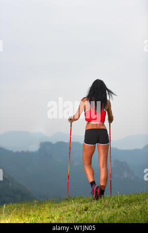 Sportliche Frau mit schönen Körper schaut sich das Panorama in die Berge während auf Trekking Stockfoto