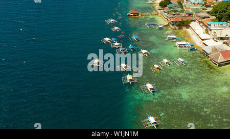 Menschen Schnorcheln über Korallenriff mit klaren, blauen Wasser des Ozeans, Ansicht von oben. Moalboal, Philippinen. Menschen schwimmen im transparenten Meer zwischen Korallenriffen. Sommer und Reisen Urlaub Konzept. Stockfoto