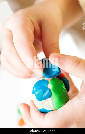 Kind Formen aus Knetmasse auf Tisch. Hände mit Knetmasse. Kleine Mädchen lernen bunte Knete zu verwenden Stockfoto