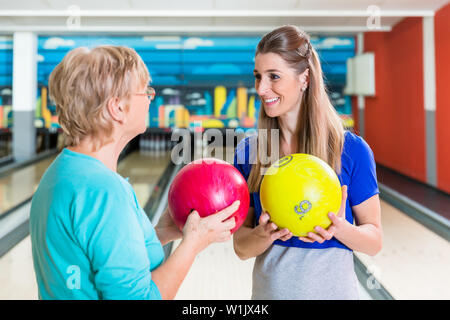 Mutter und Tochter holding Bowling Ball Stockfoto