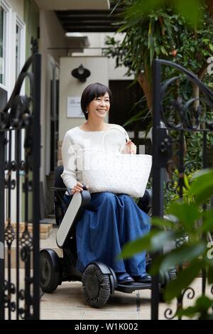 Japanische ältere Frau auf elektrischen Rollstuhl Stockfoto