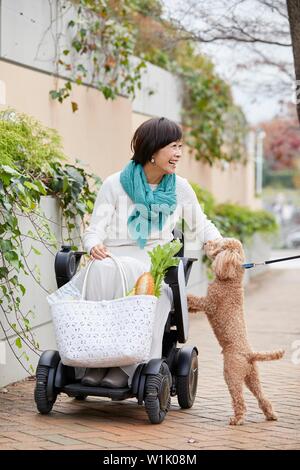 Japanische ältere Frau auf elektrischen Rollstuhl Stockfoto