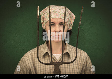 Junge Frau steht mit einer Heugabel in der Nähe von stable auf einer Ranch Stockfoto