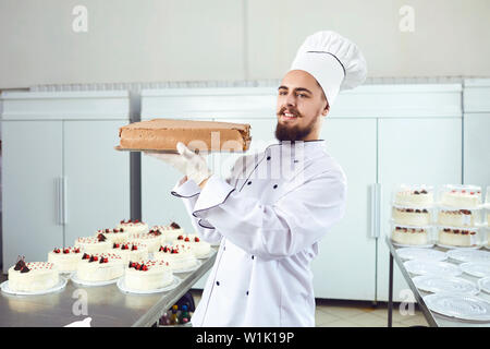 Konditor lächelnden Mann mit Kuchen in der Konditorei lächelnd Stockfoto
