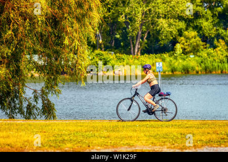 Montreal, Kanada - Juni, 2018: Ältere Frau reiten Fahrradverleih in der Nähe des Teiches in Rapids Park, Montreal, Kanada. Editorial. Stockfoto