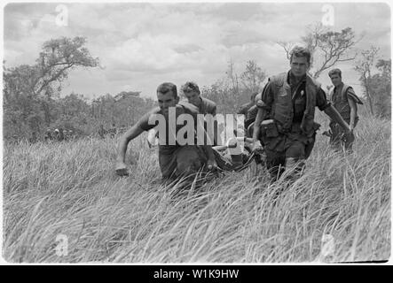 Vietnam. Medizinische Evakuierung. Marines von Firma E, 2.BATAILLON, 9 Marines, während unter schweren Feuergefecht mit NVAs innerhalb der DMZ auf dem Betrieb Hickory III, einer der Gefährten, die Marines auf die H-34. Stockfoto