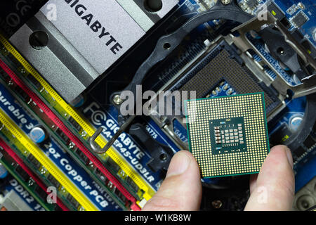 Maykop, Russland - 17. September 2016: Intel CPU bei männlichen Finger auf dem Hintergrund der Hauptplatine Gigabit, Top View close-up Stockfoto