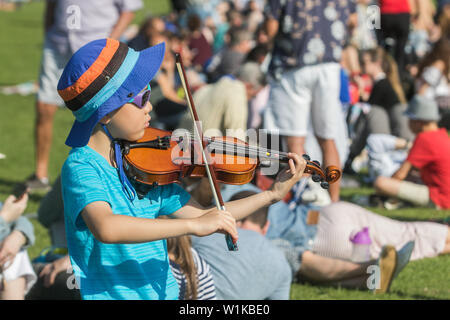 Wimbledon London, UK. 3. Juli 2019. 5 Jahre alte Jimmy spielt die Geige, während sie in der Warteschlange für Tickets im Sonnenschein am Tag drei der Wimbledon Championships. Credit: Amer ghazzal/Alamy leben Nachrichten Stockfoto