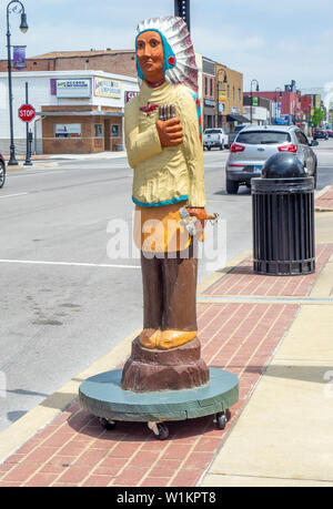 Geschnitzte hölzerne Indianer Mann hält gigars auf Hauptstraße Collinsville Illinois USA. Stockfoto