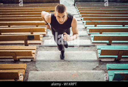 Kaukasische mann Züge, die auf der Treppe. Leichtathletik Läufer in Sport einheitliche Ausbildung outdoor. Athlet, Ansicht von oben. Schritt Übungen. Stockfoto