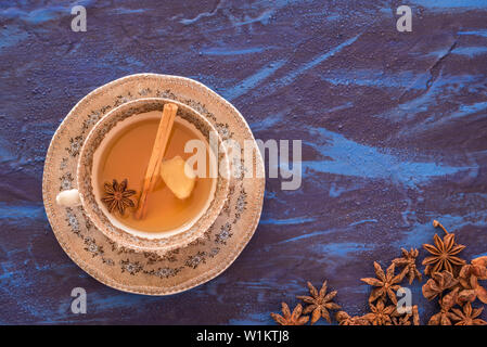 Ingwer Tee mit Anis und Zimt in Schale mit einem blauen Hintergrund serviert. Stockfoto