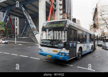 Eine Regierung Gelenkbus (Bendy Bus) Kreuze Jäger Straße auf der Elizabeth Street an einem Wintermorgen Peak Hour in Sydney, Australien Stockfoto