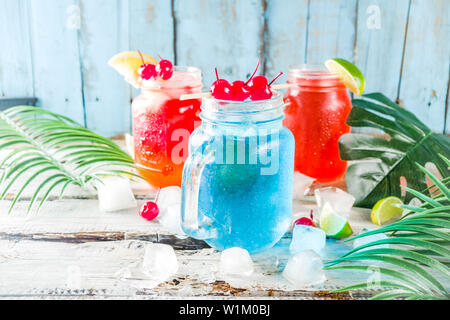 Sommer tropische kalte Getränke. Blue Hawaii, Tequila Sunrise, Sea Breeze cocktails über hellblau Holz- Strand Hintergrund Kopie Raum Stockfoto