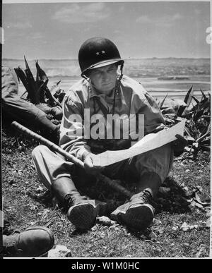 Mit der erfasst, die Hauptstadt der Naha als Hintergrund, Marine Major General Lemuel Hirte, Kommandierender General des 6. Marine Divison, entspannt auf einer Okinawanischen ridge lang genug eine Karte des Geländes zu konsultieren.; Allgemeine Hinweise: Verwenden Sie Krieg und Konflikt Nummer 1230 bei der Bestellung eine Reproduktion oder Anforderung von Informationen zu diesem Bild. Stockfoto