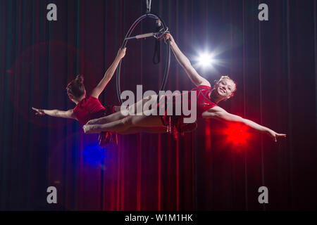 Zirkus Schauspielerin acrobat Leistung. Zwei Mädchen führen akrobatische Elemente in der Luft. Stockfoto