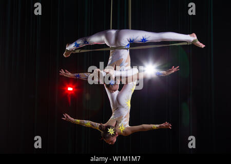 Zirkus Schauspielerin acrobat Leistung. Zwei Mädchen führen akrobatische Elemente in der Luft. Stockfoto