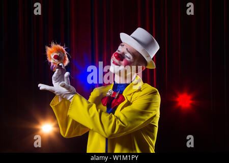 Zirkus Clown führt. Ein Mann in einem Clown Outfit mit einem Spielzeug Stockfoto