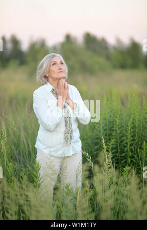 Portrait von Happy senior schöne Frau zu beten Stockfoto