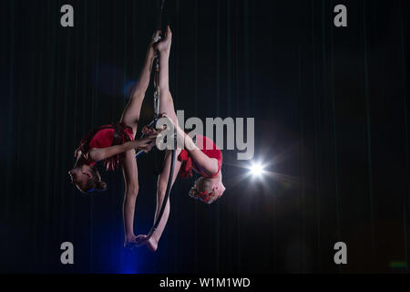 Zirkus Schauspielerin acrobat Leistung. Zwei Mädchen führen akrobatische Elemente in der Luft. Stockfoto