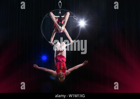 Zirkus Schauspielerin acrobat Leistung. Zwei Mädchen führen akrobatische Elemente in der Luft. Stockfoto