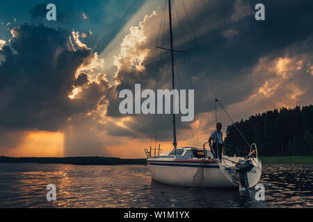 Koronowo / Polen - Jun 7.2007: Blick auf die Fischer auf die Yacht mit der epischen Sonnenuntergang Himmel auf dem See im Hintergrund. Stockfoto