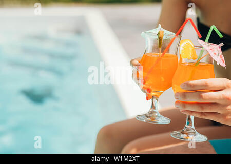 Glas frisch gepresster Orangensaft am Pool. Sommer cocktail Stockfoto