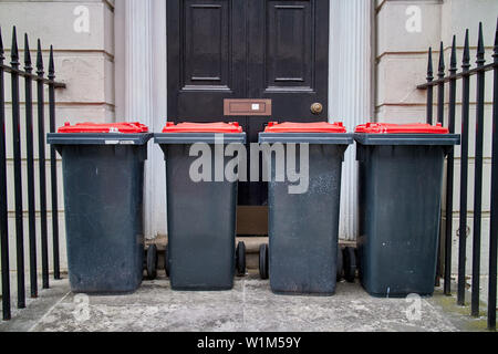 Vier wheelie bins Stand außerhalb einer Vordertür. Stockfoto