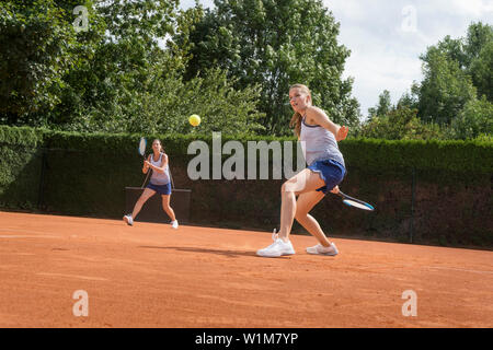 Zwei Frauen Tennis spielen an einem sonnigen Tag, Bayern, Deutschland Stockfoto