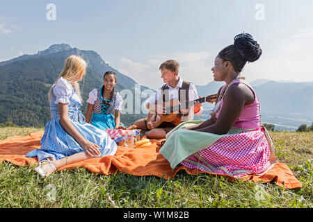 Teenage Freunde genießen mit Gitarre beim Picknick, Bayern, Deutschland Stockfoto