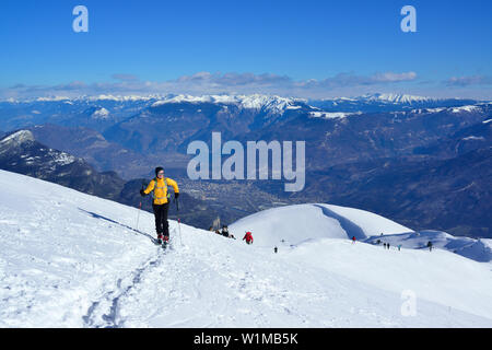 Weibliche zurück - Langläufer aufsteigend bis zum Monte Baldo, Alpine Valley Etschtal im Hintergrund, Monte Baldo Gardasee Berge, Trentino, Italien Stockfoto