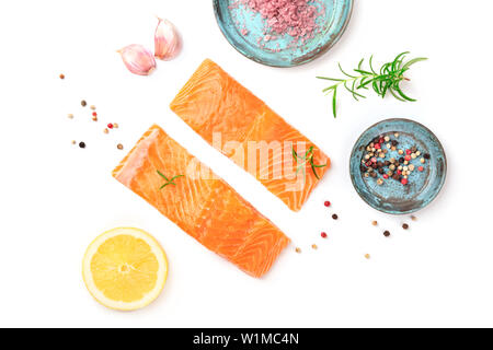 Zwei Scheiben frischen, rohen Lachs mit Himalaya Salz, Pfeffer, Rosmarin, Knoblauch, Zitrone, geschossen von oben auf einen weißen Hintergrund mit Kopie Raum Stockfoto