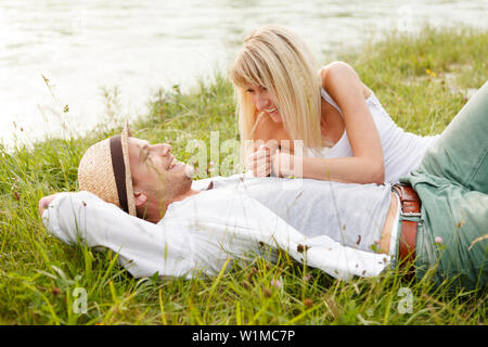 Junges Paar am Ufer Isar, München, Bayern, Deutschland Stockfoto