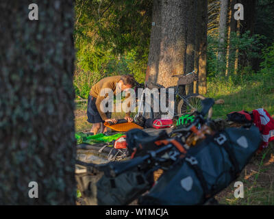 Bike Verpackung im Hochschwarzwald. Mountain Biker (M 49) eine Pause, im Hintergrund Mountainbike mit Fahrrad Verpackung - Ausrüstung, Baden Württemberg, Deutschland Stockfoto