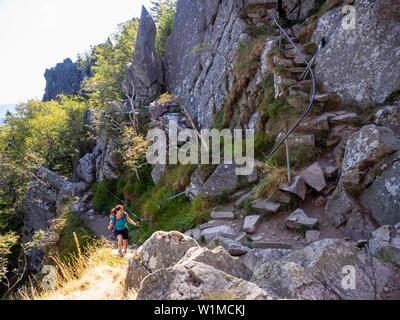 Frauen Klettern bis auf schmalen Felsen in den Vogesen im Elsass am Lac Blanc, Frankreich Stockfoto