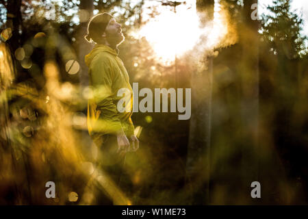 Junge männliche Läufer in eine kurze Pause in einem Wald, Allgäu, Bayern, Deutschland Stockfoto