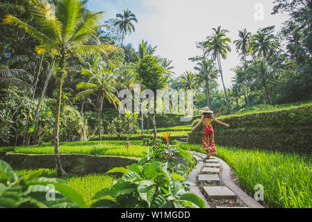 Schöne Mädchen, die in den Reisfeldern in Bali tegalalang, Ubud. Konzept über Menschen, Fernweh Reisen und Tourismus lifestyle Stockfoto