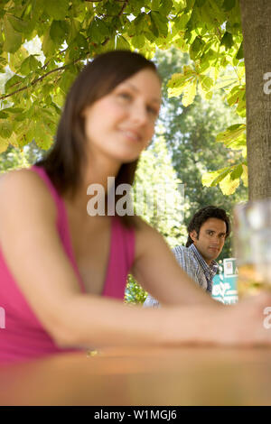 Flirten Sie im Bier Garten, junge Frau und Mann Flirten im Biergarten, Starnberger See, Bayern, Deutschland Stockfoto