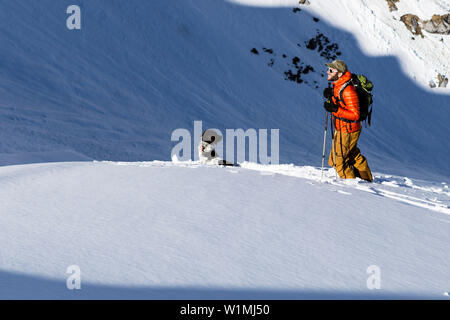 Backcountry skier mit seinem Hund in den Ammergauer Alpen, Bayern, Deutschland Stockfoto