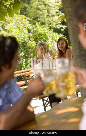 Flirten im Biergarten, zwei junge Frauen und zwei Männer flirten im Biergarten, Starnberger See, Bayern, Deutschland Stockfoto