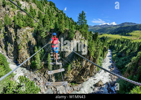 Frau Kreuzung Schlucht auf der Hängebrücke, Obergurgler Klettersteig, fixed-rope Route, Obergurgl, Ötztaler Alpen, Tirol, Österreich Stockfoto